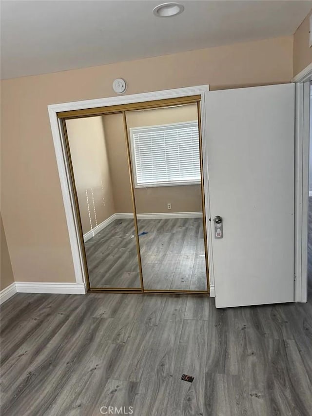 3880 W Jacinto View Rd Unit M, Banning, CA 92220 - unfurnished bedroom with wood finished floors, a closet, and baseboards
