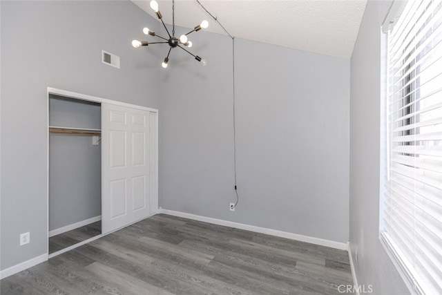 28031 Sarabande Ln Unit 128, Canyon Country, CA 91387 - unfurnished bedroom featuring a chandelier, wood finished floors, baseboards, a closet, and high vaulted ceiling