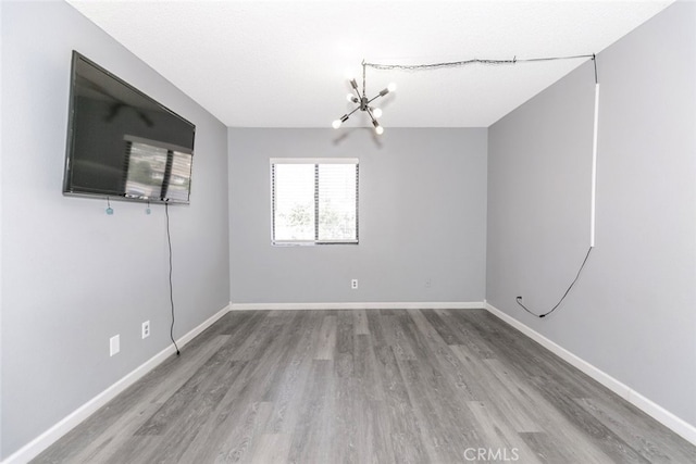 28031 Sarabande Ln Unit 128, Canyon Country, CA 91387 - spare room with a chandelier, wood finished floors, and baseboards