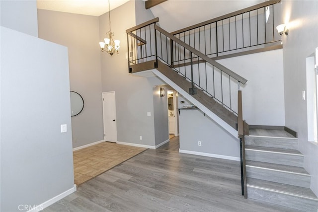 28031 Sarabande Ln Unit 128, Canyon Country, CA 91387 - stairway with a towering ceiling, wood finished floors, a chandelier, and baseboards