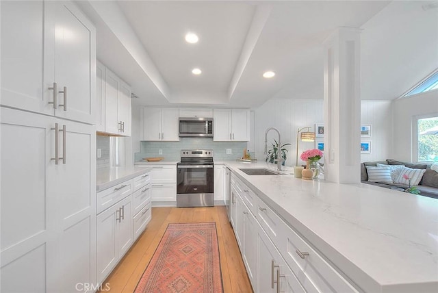 4326 Via Verde, Cypress, CA 90630 - kitchen with appliances with stainless steel finishes, light wood-style flooring, white cabinetry, tasteful backsplash, and recessed lighting