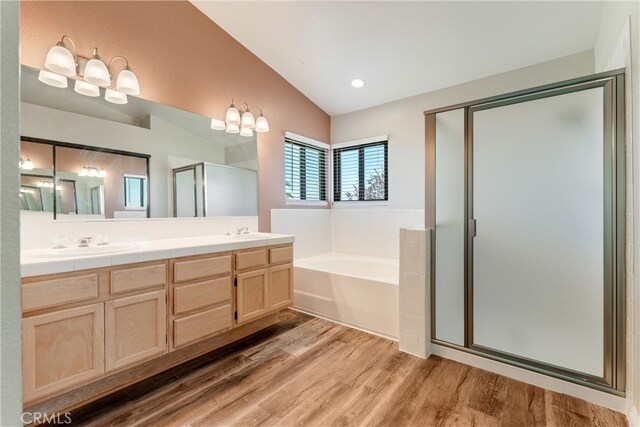 5809 Almond Valley Way, Lancaster, CA 93536 - full bath featuring wood finished floors, vaulted ceiling, a bath, a stall shower, and double vanity