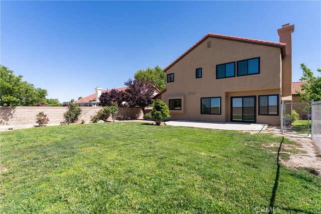 5809 Almond Valley Way, Lancaster, CA 93536 - back of house with stucco siding, a chimney, a tiled roof, and a patio