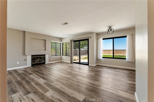 5809 Almond Valley Way, Lancaster, CA 93536 - unfurnished living room with baseboards, dark wood-style flooring, and a tiled fireplace