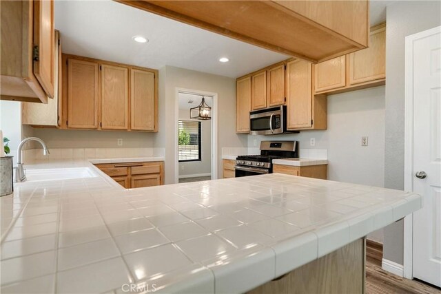 5809 Almond Valley Way, Lancaster, CA 93536 - kitchen with appliances with stainless steel finishes, a sink, tile counters, a peninsula, and recessed lighting