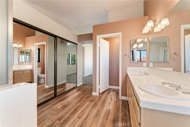 5809 Almond Valley Way, Lancaster, CA 93536 - bathroom with toilet, a chandelier, wood finished floors, and double vanity