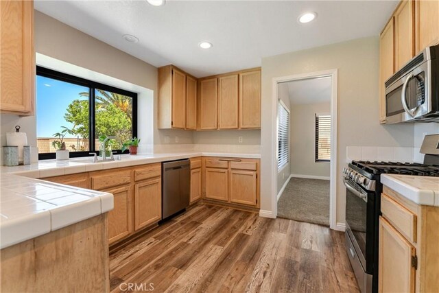 5809 Almond Valley Way, Lancaster, CA 93536 - kitchen with stainless steel appliances, a sink, light brown cabinetry, wood finished floors, and recessed lighting