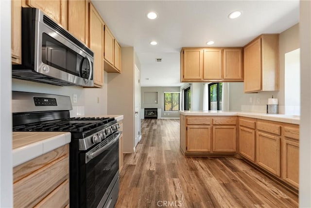 5809 Almond Valley Way, Lancaster, CA 93536 - kitchen featuring stainless steel appliances, tile countertops, wood finished floors, a peninsula, and recessed lighting