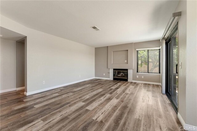 5809 Almond Valley Way, Lancaster, CA 93536 - unfurnished living room featuring wood finished floors, baseboards, and a glass covered fireplace