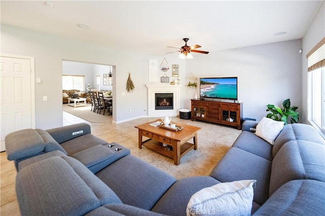 31786 Sorrel Run Ct, Menifee, CA 92584 - living area featuring healthy amount of natural light, ceiling fan, light tile patterned floors, and a warm lit fireplace