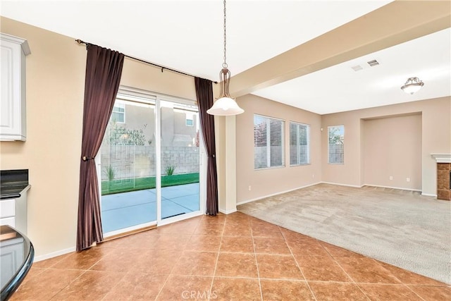 44224 Raven Ln, Lancaster, CA 93536 - unfurnished dining area featuring light carpet, baseboards, light tile patterned flooring, and a fireplace