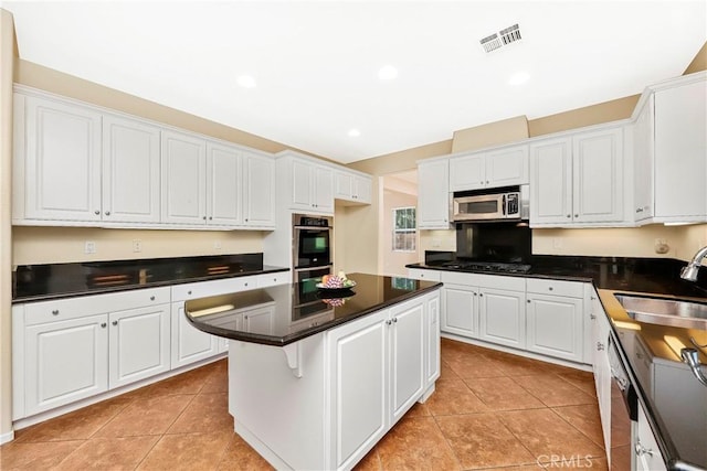 44224 Raven Ln, Lancaster, CA 93536 - kitchen with a sink, stainless steel appliances, dark countertops, white cabinetry, and recessed lighting