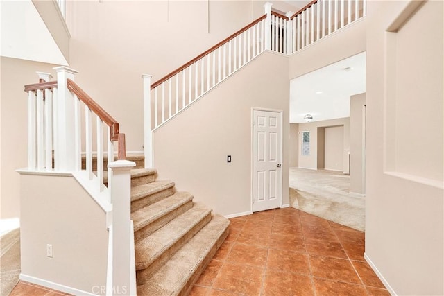 44224 Raven Ln, Lancaster, CA 93536 - staircase with a high ceiling, carpet floors, baseboards, and tile patterned flooring