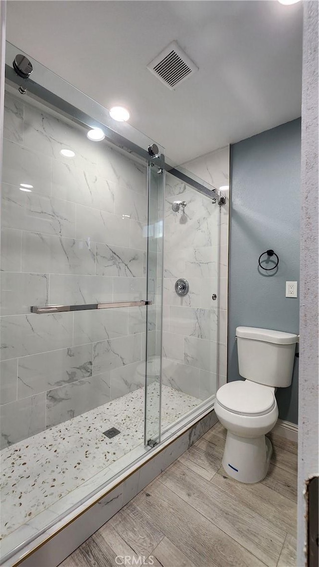 2045 S Cypress Ave, Ontario, CA 91762 - bathroom featuring toilet, a marble finish shower, wood finished floors, and baseboards