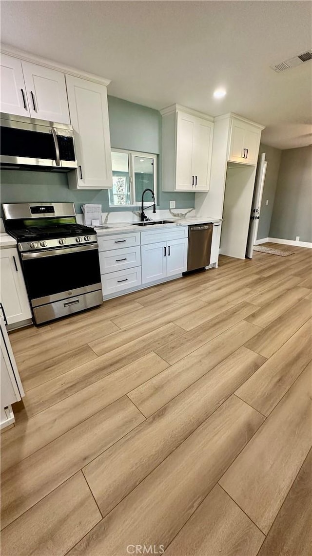 2045 S Cypress Ave, Ontario, CA 91762 - kitchen featuring stainless steel appliances, white cabinets, light countertops, light wood-style flooring, and recessed lighting