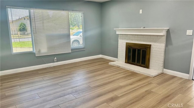 2045 S Cypress Ave, Ontario, CA 91762 - unfurnished living room with wood finished floors, healthy amount of natural light, and a brick fireplace