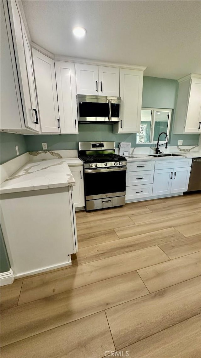 2045 S Cypress Ave, Ontario, CA 91762 - kitchen with stainless steel appliances, white cabinetry, light wood-style flooring, light stone counters, and recessed lighting