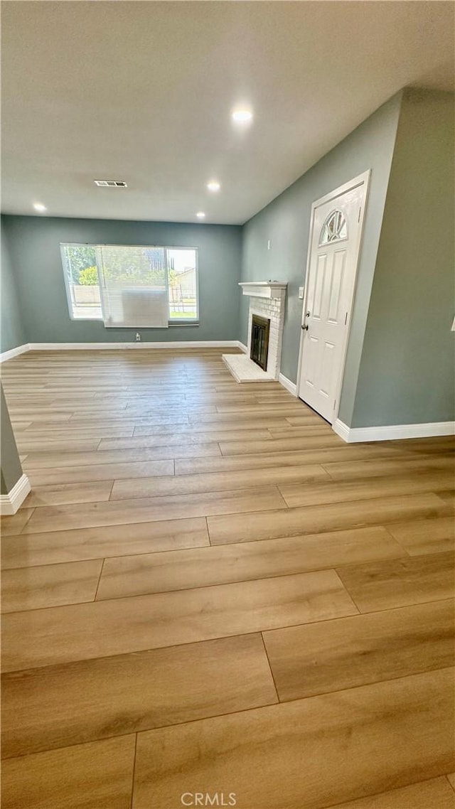 2045 S Cypress Ave, Ontario, CA 91762 - unfurnished living room featuring light wood-style flooring, a glass covered fireplace, and recessed lighting