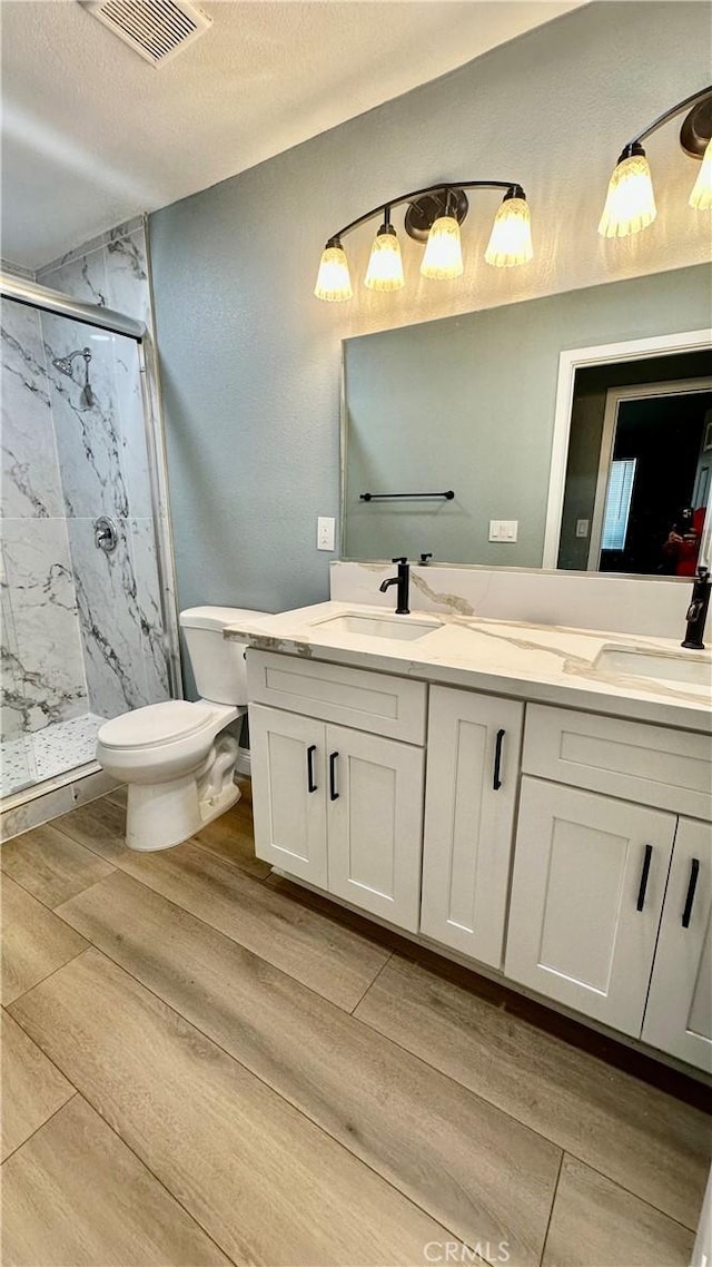 2045 S Cypress Ave, Ontario, CA 91762 - bathroom with a marble finish shower, double vanity, wood finished floors, and a textured ceiling