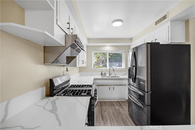 1881 Mitchell Ave Unit 34, Tustin, CA 92780 - kitchen featuring freestanding refrigerator, gas stove, a sink, light wood-style flooring, and white cabinetry