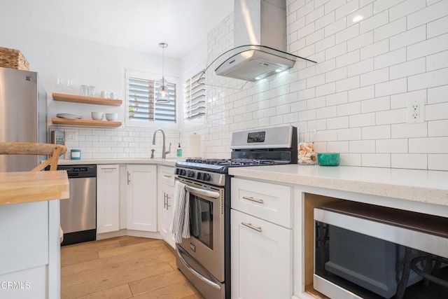 244 Cahuenga Dr, Oxnard, CA 93035 - kitchen with appliances with stainless steel finishes, wall chimney exhaust hood, tasteful backsplash, white cabinets, and a sink