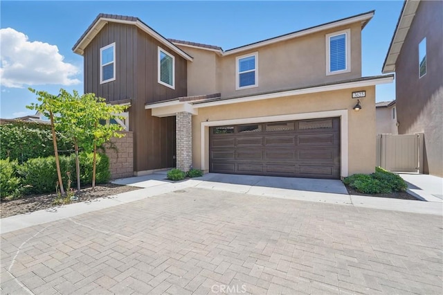 3625 Basanite Ave, Ontario, CA 91761 - view of front facade featuring an attached garage, decorative driveway, board and batten siding, and stucco siding