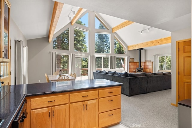 120 Top Of The W Dr, Chester, CA 96020 - kitchen featuring a wood stove, beamed ceiling, light carpet, high vaulted ceiling, and dark stone countertops