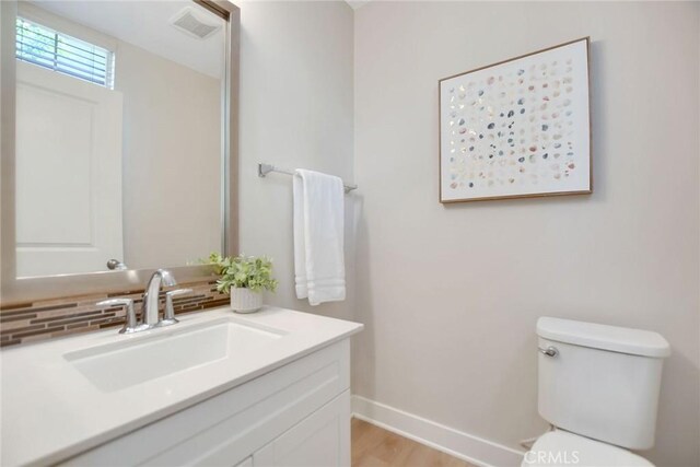 908 N Alameda Ave, Azusa, CA 91702 - bathroom featuring tasteful backsplash, vanity, toilet, baseboards, and wood finished floors
