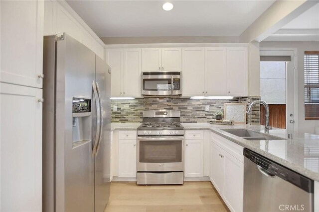 908 N Alameda Ave, Azusa, CA 91702 - kitchen with appliances with stainless steel finishes, a sink, white cabinets, and light stone counters