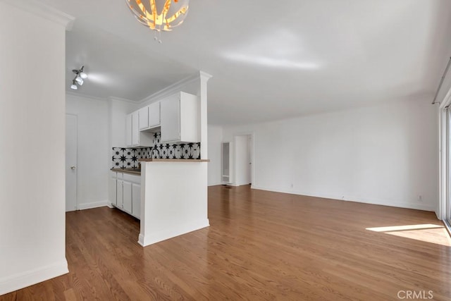 1020 Granville Ave Unit 205, Los Angeles, CA 90049 - kitchen with tasteful backsplash, wood finished floors, a chandelier, white cabinetry, and open floor plan