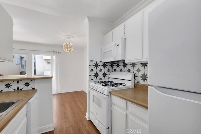 1020 Granville Ave Unit 205, Los Angeles, CA 90049 - kitchen with white appliances, tasteful backsplash, white cabinets, wood finished floors, and crown molding