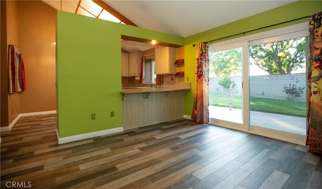 5515 Katrina Pl, Palmdale, CA 93552 - kitchen featuring dark wood-type flooring, vaulted ceiling, light countertops, and a breakfast bar area