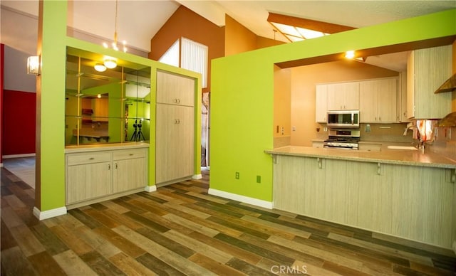 5515 Katrina Pl, Palmdale, CA 93552 - kitchen with appliances with stainless steel finishes, dark wood-style flooring, high vaulted ceiling, a peninsula, and a breakfast bar area