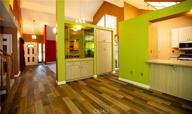 5515 Katrina Pl, Palmdale, CA 93552 - kitchen with appliances with stainless steel finishes, dark wood finished floors, high vaulted ceiling, and a breakfast bar area