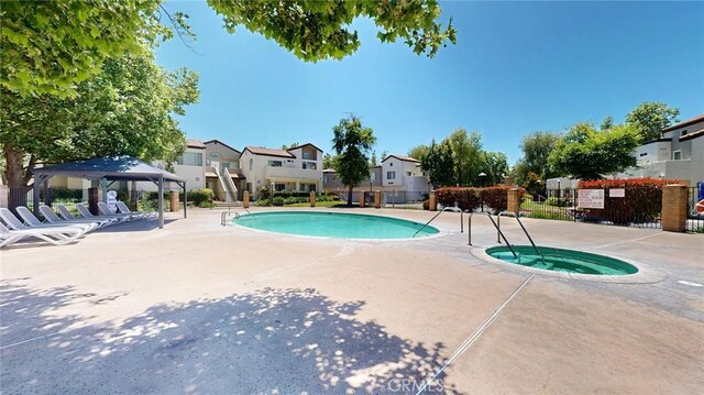 24420 Flaxwood Ln Unit 204, Newhall, CA 91321 - community pool with a gazebo, a community hot tub, a residential view, and a patio area