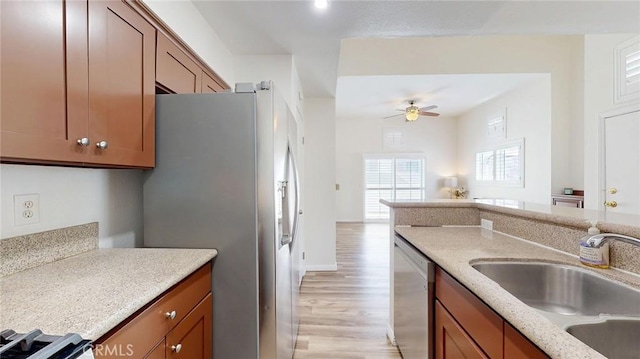 24420 Flaxwood Ln Unit 204, Newhall, CA 91321 - kitchen featuring stainless steel appliances, a sink, brown cabinetry, and open floor plan