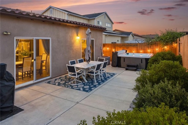 255 Waterfall Rd, Templeton, CA 93465 - patio terrace at dusk featuring a hot tub, a patio, and a fenced backyard