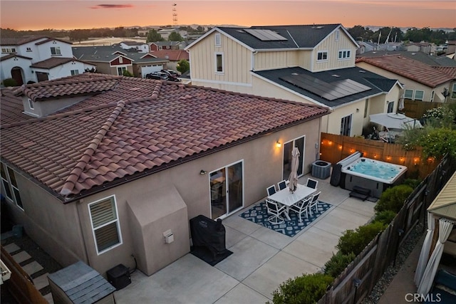 255 Waterfall Rd, Templeton, CA 93465 - back of property at dusk with a residential view, stucco siding, roof mounted solar panels, and a fenced backyard