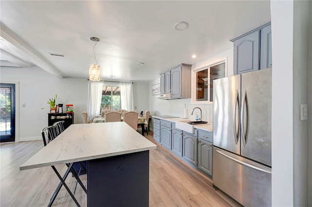 1111 W Berkeley Ct, Ontario, CA 91762 - kitchen with freestanding refrigerator, a sink, gray cabinetry, a center island, and light wood finished floors