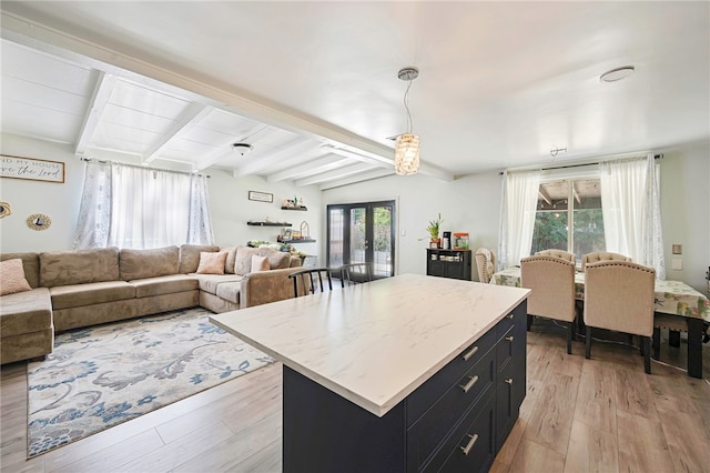 1111 W Berkeley Ct, Ontario, CA 91762 - kitchen with dark cabinets, light wood-style floors, beam ceiling, open floor plan, and a center island