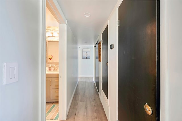 1111 W Berkeley Ct, Ontario, CA 91762 - hallway featuring light wood-type flooring, baseboards, and a sink