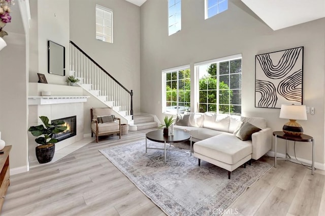 19 Laurelhurst Dr, Ladera Ranch, CA 92694 - living room with a towering ceiling, wood finished floors, a fireplace with flush hearth, stairs, and baseboards