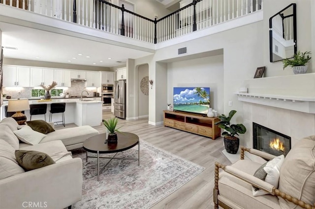 19 Laurelhurst Dr, Ladera Ranch, CA 92694 - living room with a high ceiling, a tile fireplace, light wood-style floors, baseboards, and recessed lighting