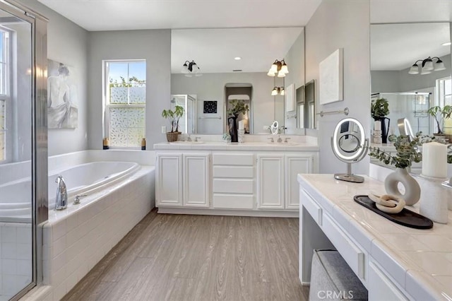 19 Laurelhurst Dr, Ladera Ranch, CA 92694 - bathroom featuring a garden tub, wood finished floors, double vanity, a stall shower, and recessed lighting