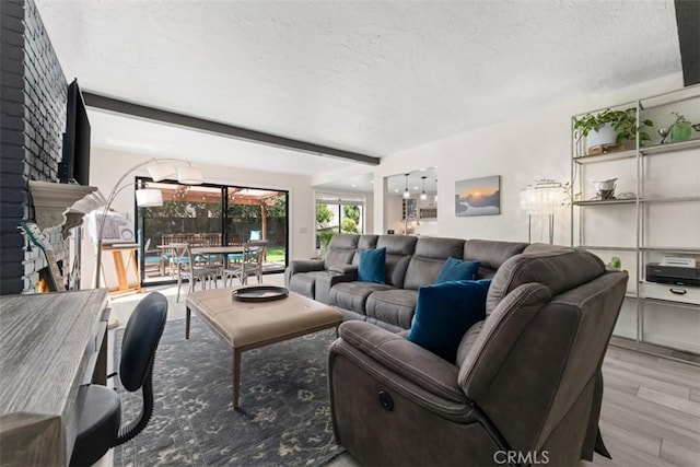 1520 Downs St, Oceanside, CA 92054 - living area with wood finished floors, a textured ceiling, a lit fireplace, and beamed ceiling
