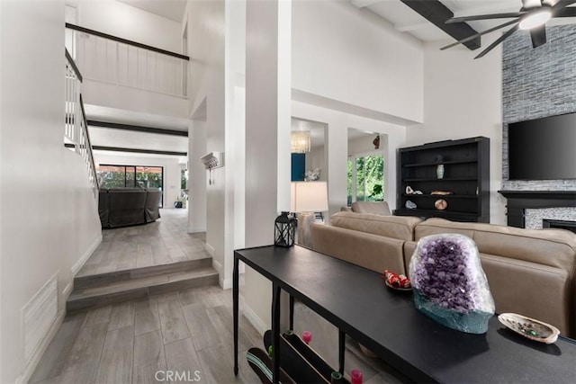 1520 Downs St, Oceanside, CA 92054 - living room featuring a towering ceiling, ceiling fan, wood finished floors, a fireplace, and baseboards