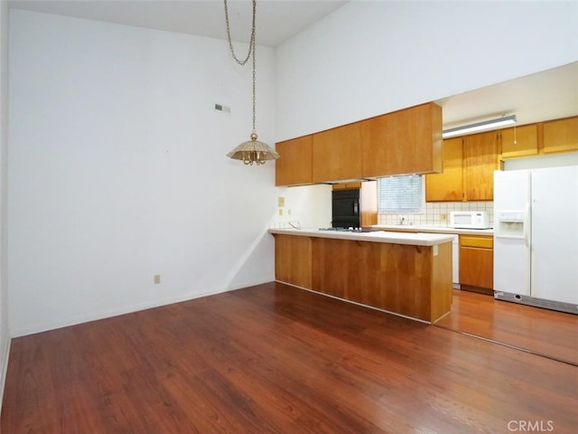 3819 W 190th St, Torrance, CA 90504 - kitchen featuring white appliances, brown cabinetry, a peninsula, and dark wood finished floors