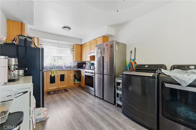 1089 E Columbia Ave, Pomona, CA 91767 - kitchen with appliances with stainless steel finishes, under cabinet range hood, washing machine and clothes dryer, light wood finished floors, and light brown cabinets