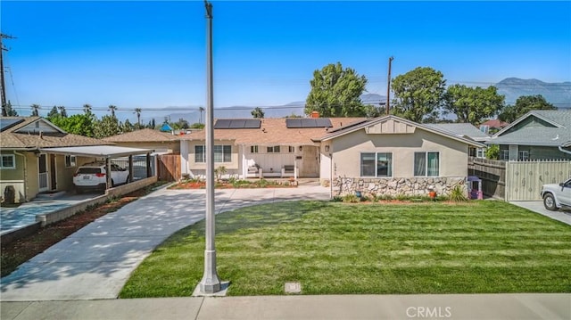 1089 E Columbia Ave, Pomona, CA 91767 - ranch-style house with solar panels, stucco siding, concrete driveway, and a detached carport
