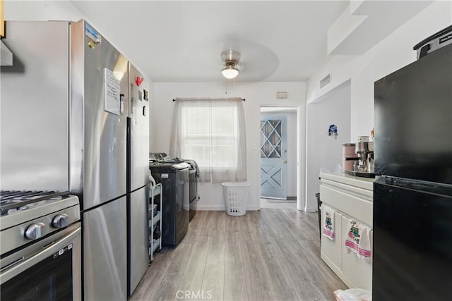 1089 E Columbia Ave, Pomona, CA 91767 - kitchen with freestanding refrigerator, gas range, ceiling fan, light wood-style flooring, and washer / dryer
